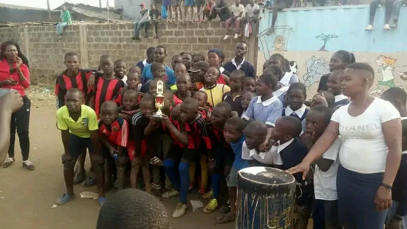 Children celebrating with a trophy and drum at an OTEGA Foundation talent event in Mathare Mradi